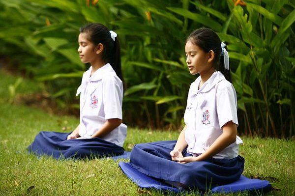 芝生で瞑想する女の子たち