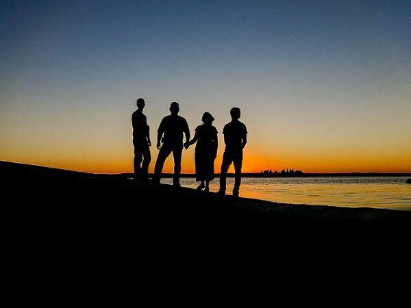 夕日を眺める４人のシルエット